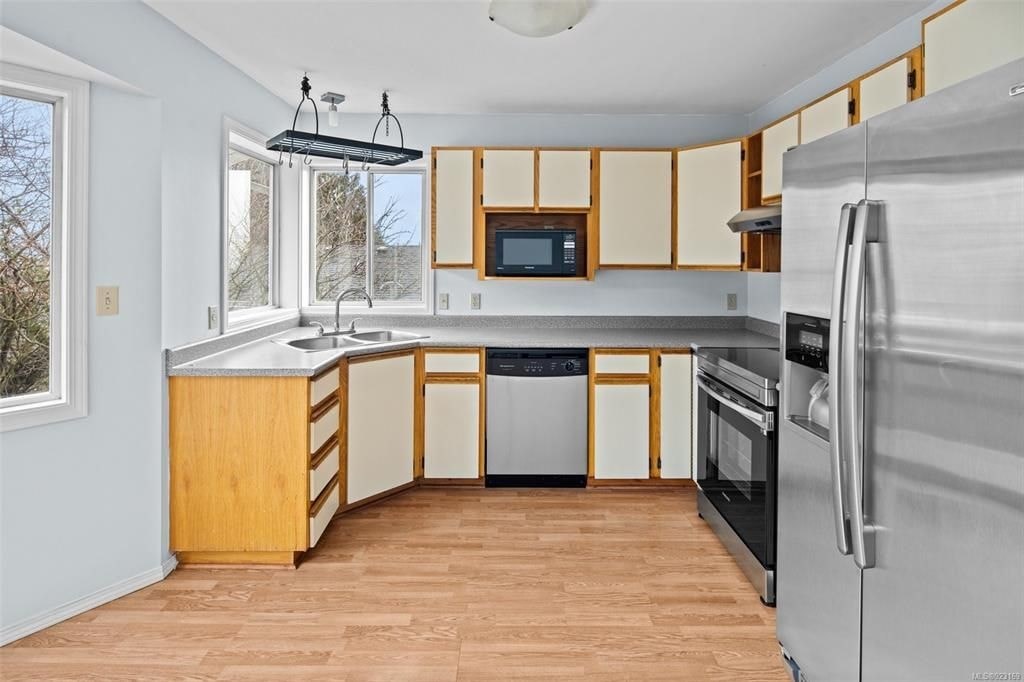A kitchen with wooden cabinets and a stainless steel refrigerator.