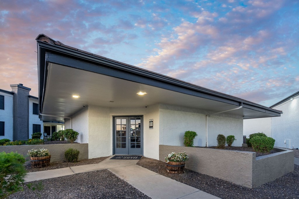 A modern house with a grey front door and a small garden area.