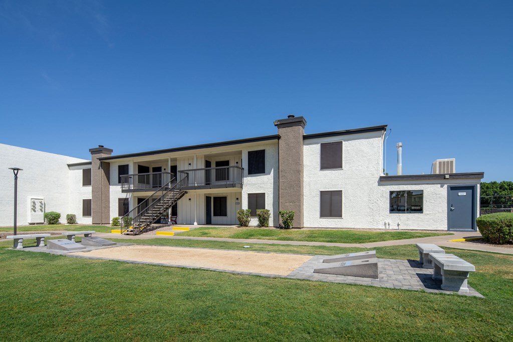 A modern building with a white exterior and a grey roof.