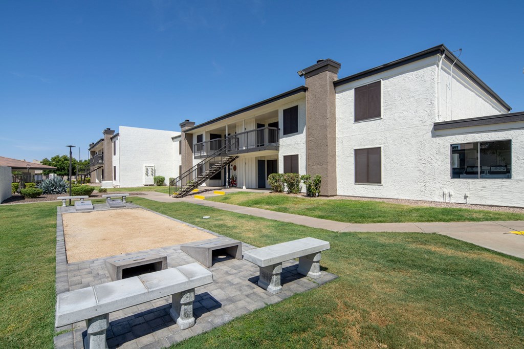 A white building with a patio and a fire pit.