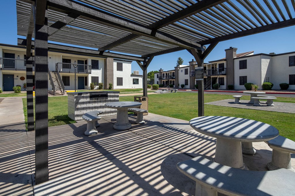 A shaded outdoor area with tables and benches.