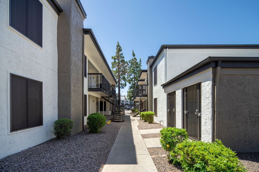 A row of houses with a sidewalk in between.