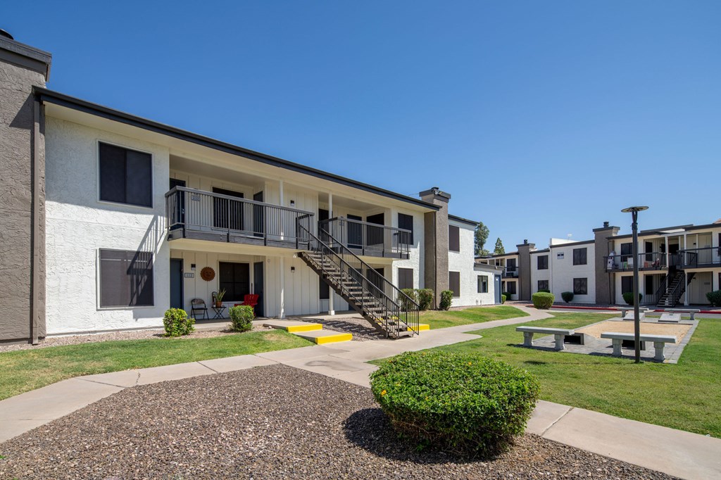A small white building with a black roof and a small balcony.