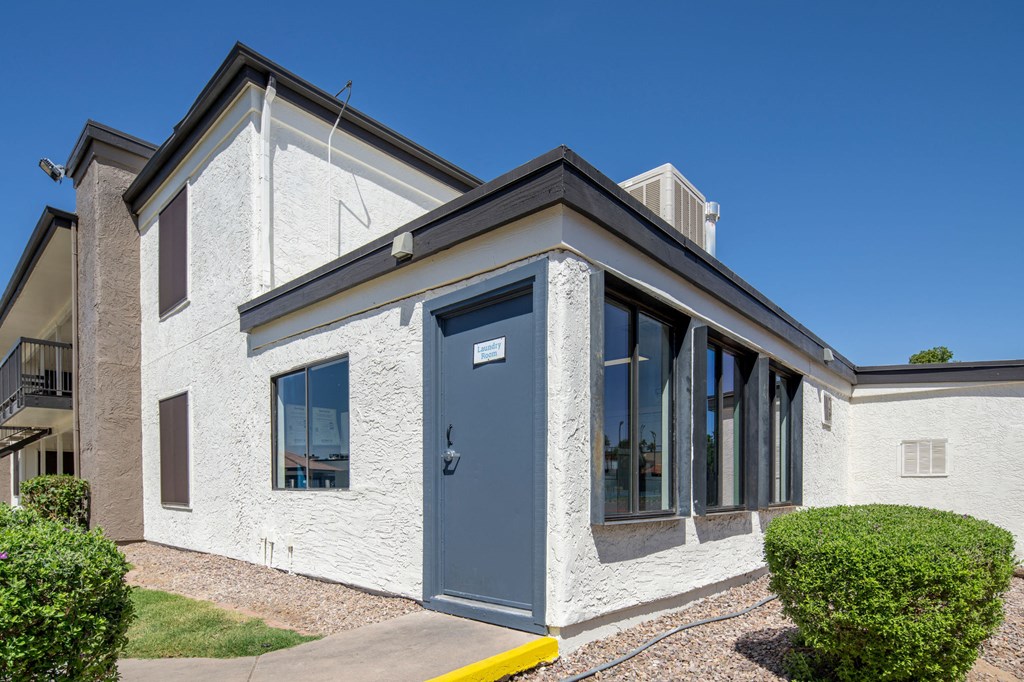 A white house with a grey door and windows.