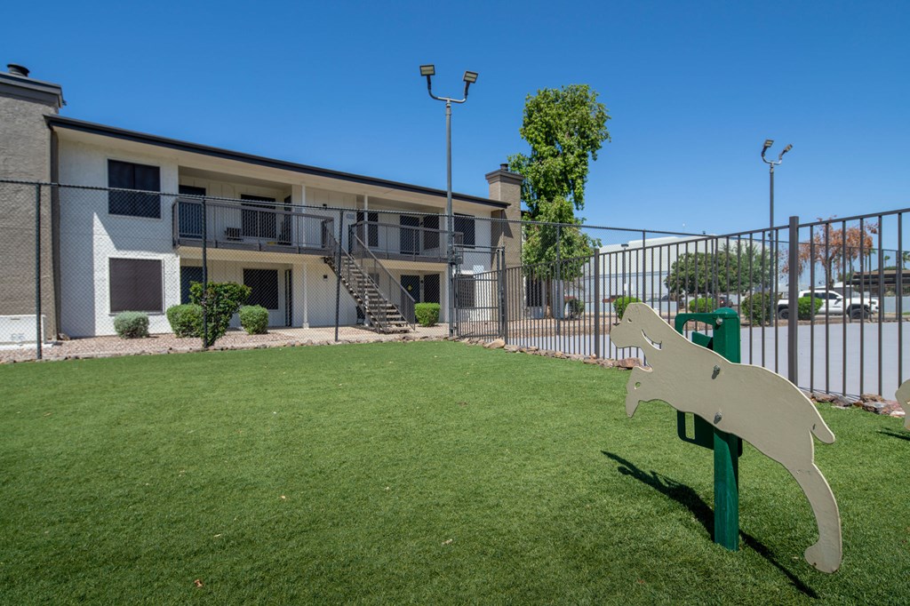 A green lawn in front of a building with a white rabbit sculpture.
