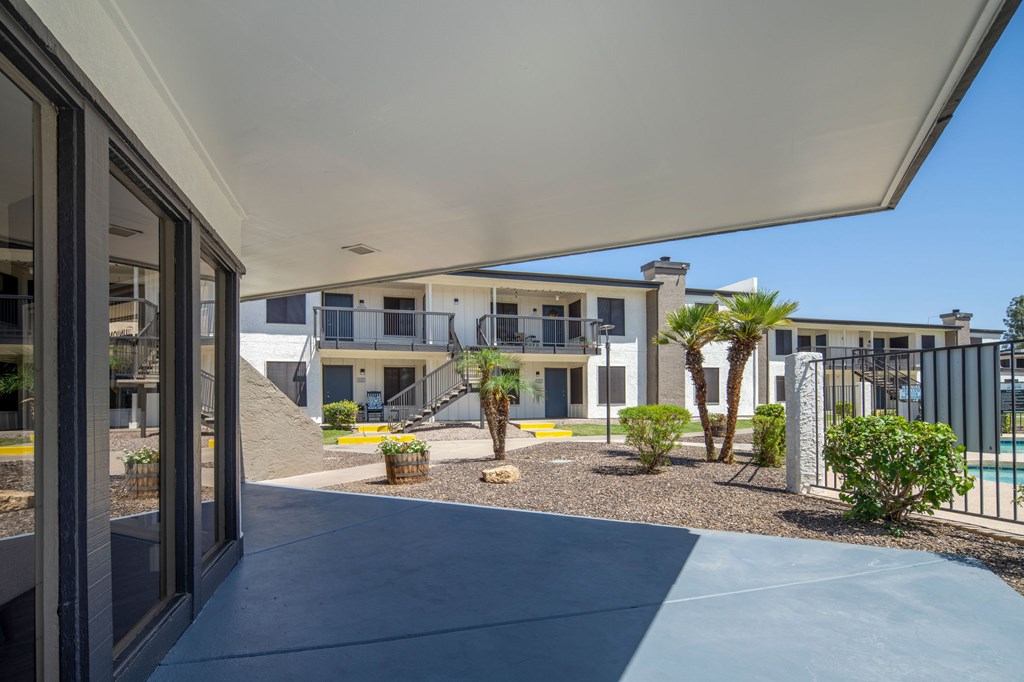A modern building with a pool and palm trees in the foreground.