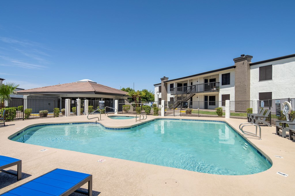 A swimming pool with a blue bench and a building in the background.