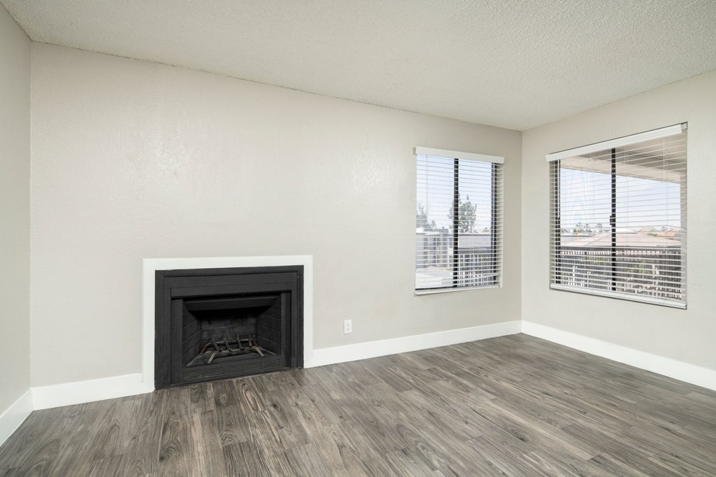 A room with a fireplace and a window with blinds.