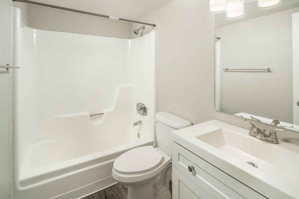 A white bathroom with a toilet, sink, and bathtub.