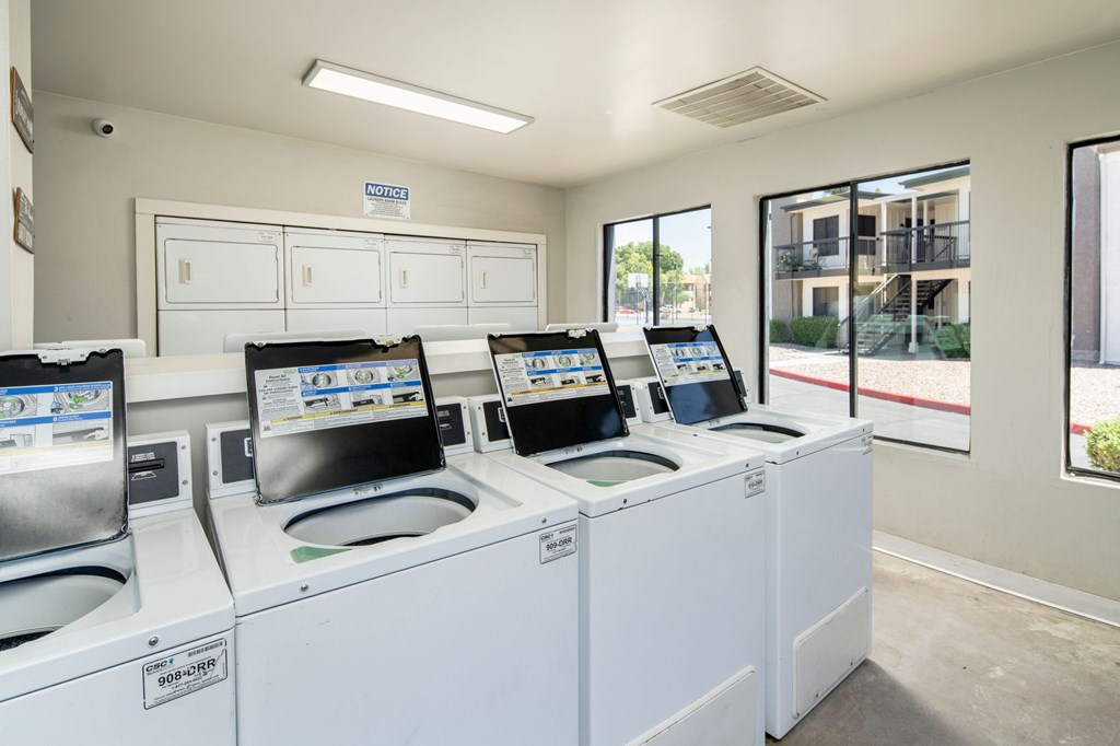 A row of washing machines are lined up in a laundromat.