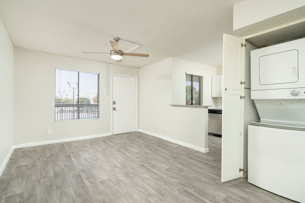 A room with a ceiling fan and a window with blinds.