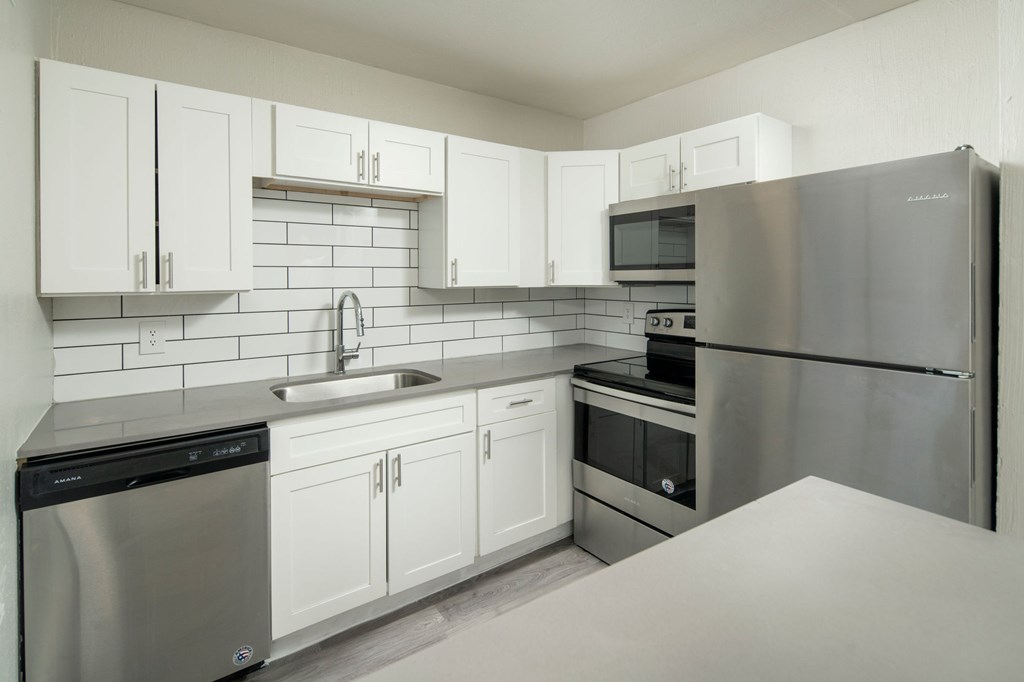 A kitchen with white cabinets and stainless steel appliances.