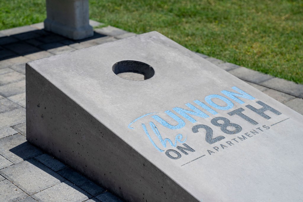 Concrete block with a hole in the middle and the words "Union on 28th Apartments" painted on it.
