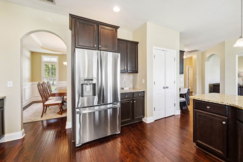 a kitchen with a stainless steel refrigerator and wooden cabinets