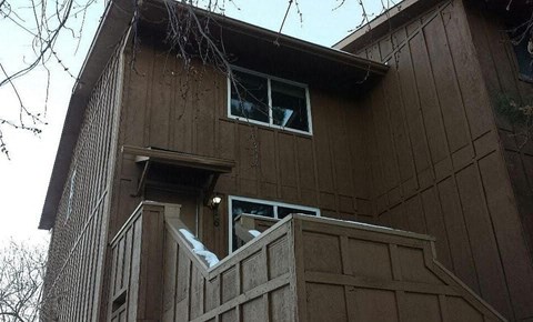A brown wooden house with a window and a door.