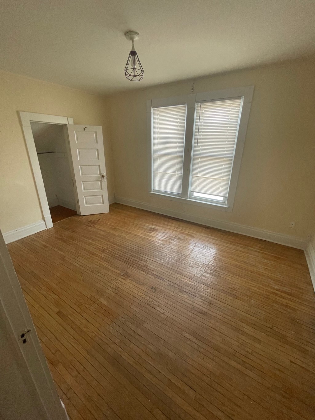 A room with wooden flooring and a white door.