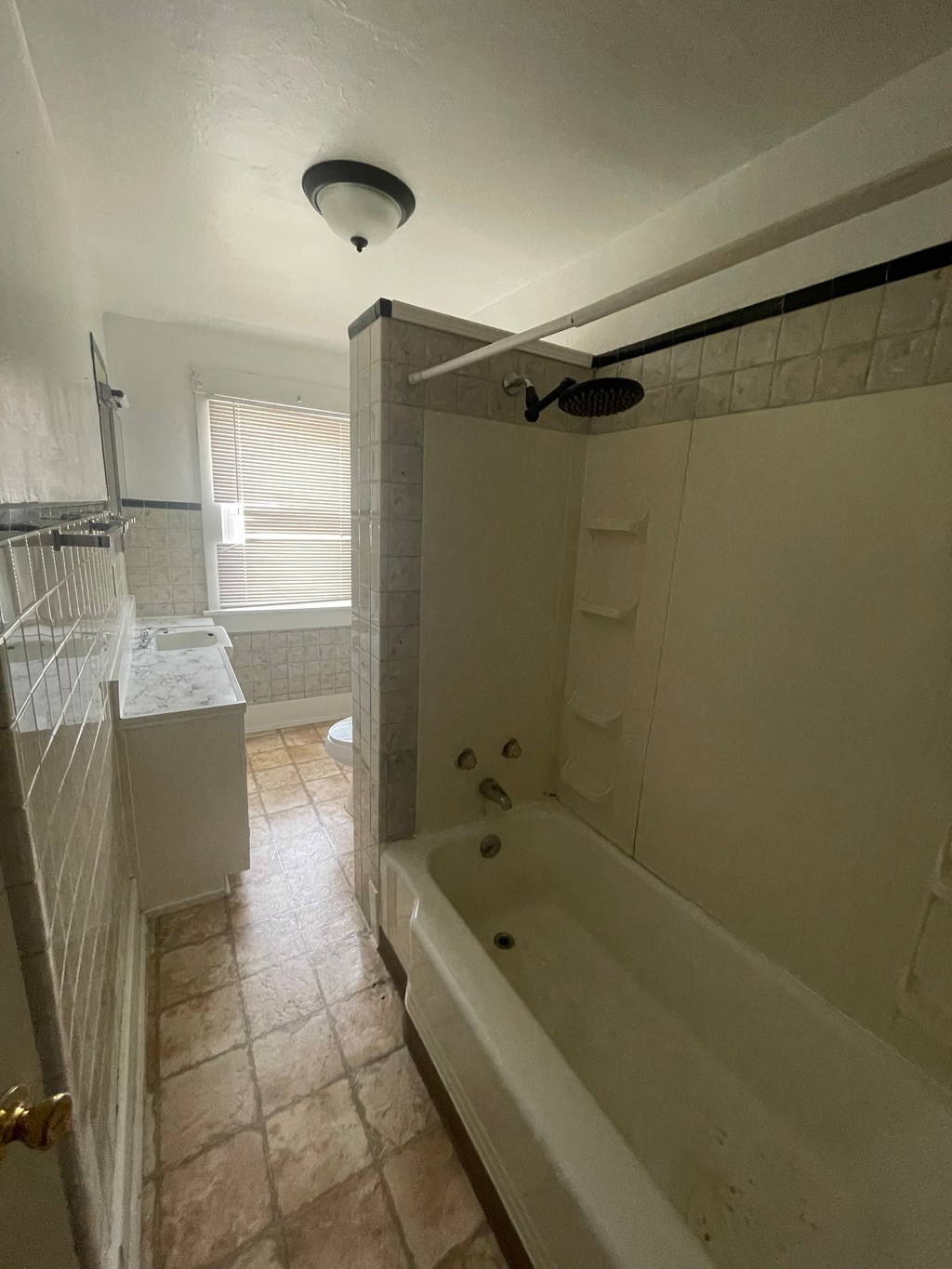 A white bathroom with a shower and a towel rack.