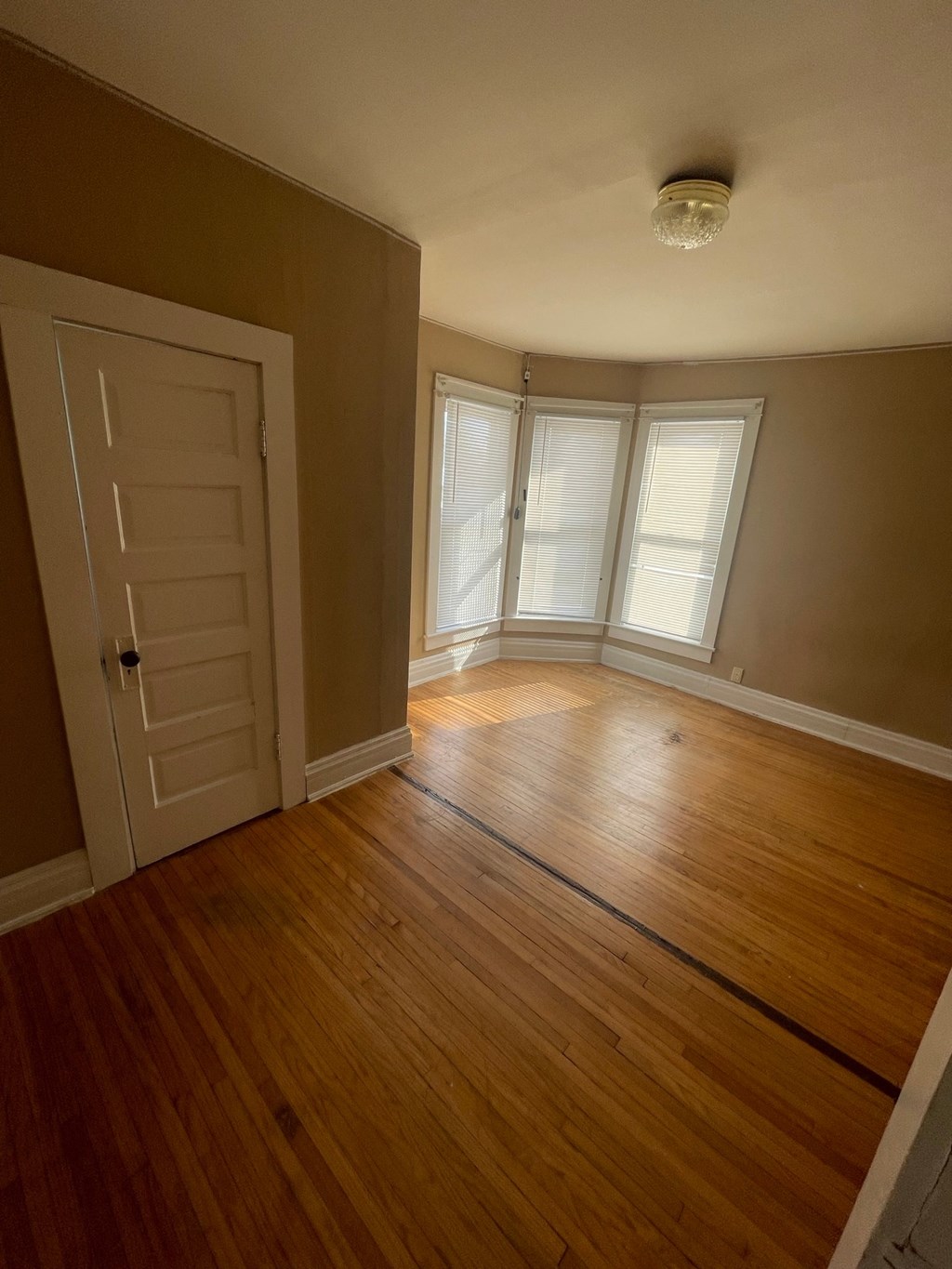 A room with wooden floors and a white door.