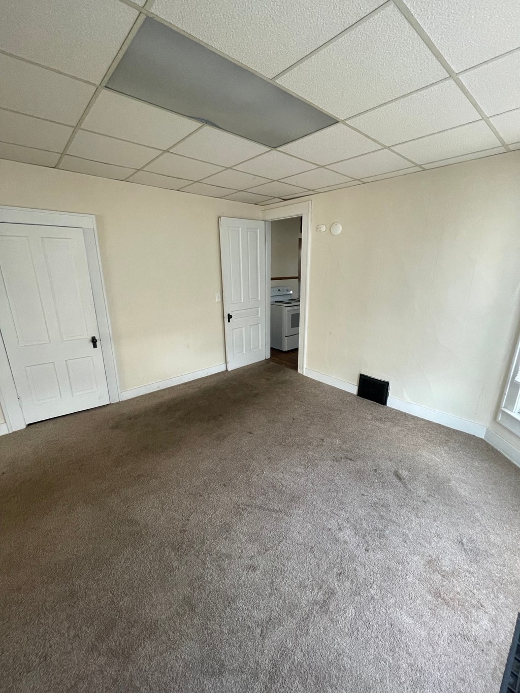 A room with a carpeted floor and a ceiling with a light fixture.