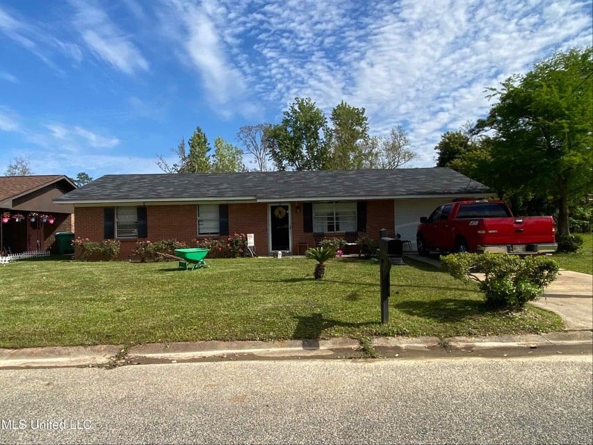 A red truck is parked in front of a house.