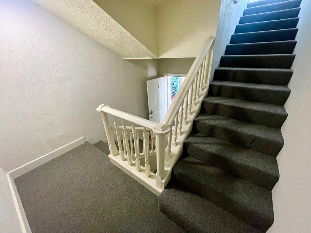 A staircase with a white railing and black steps.