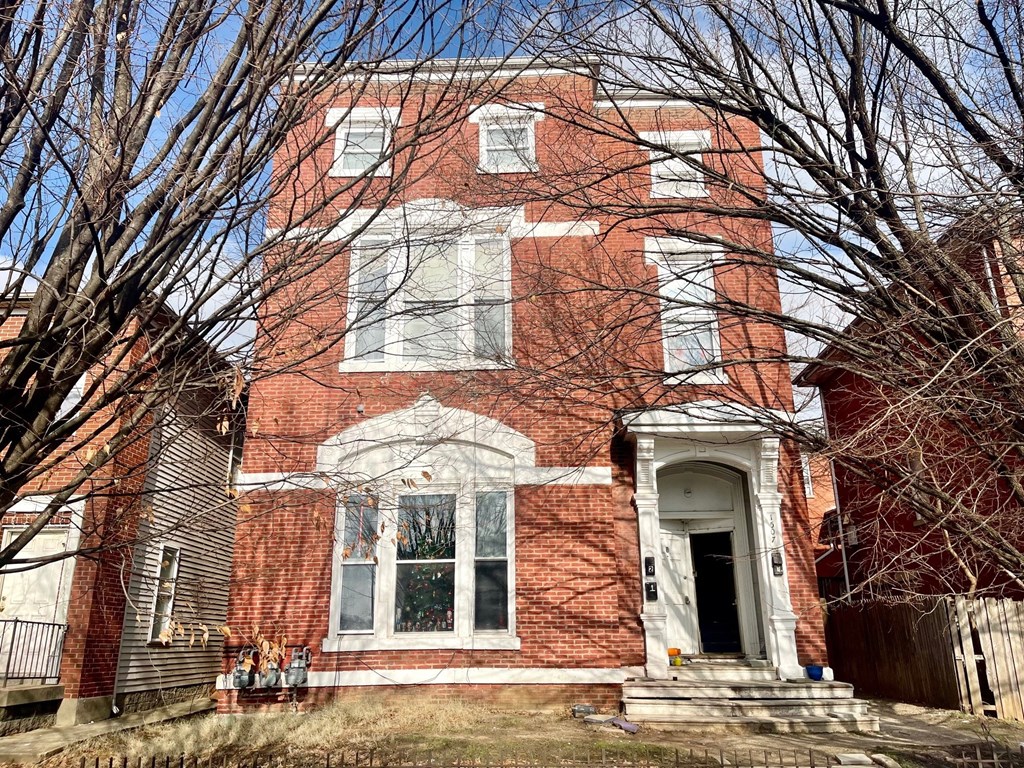 A red brick house with a white door and windows.
