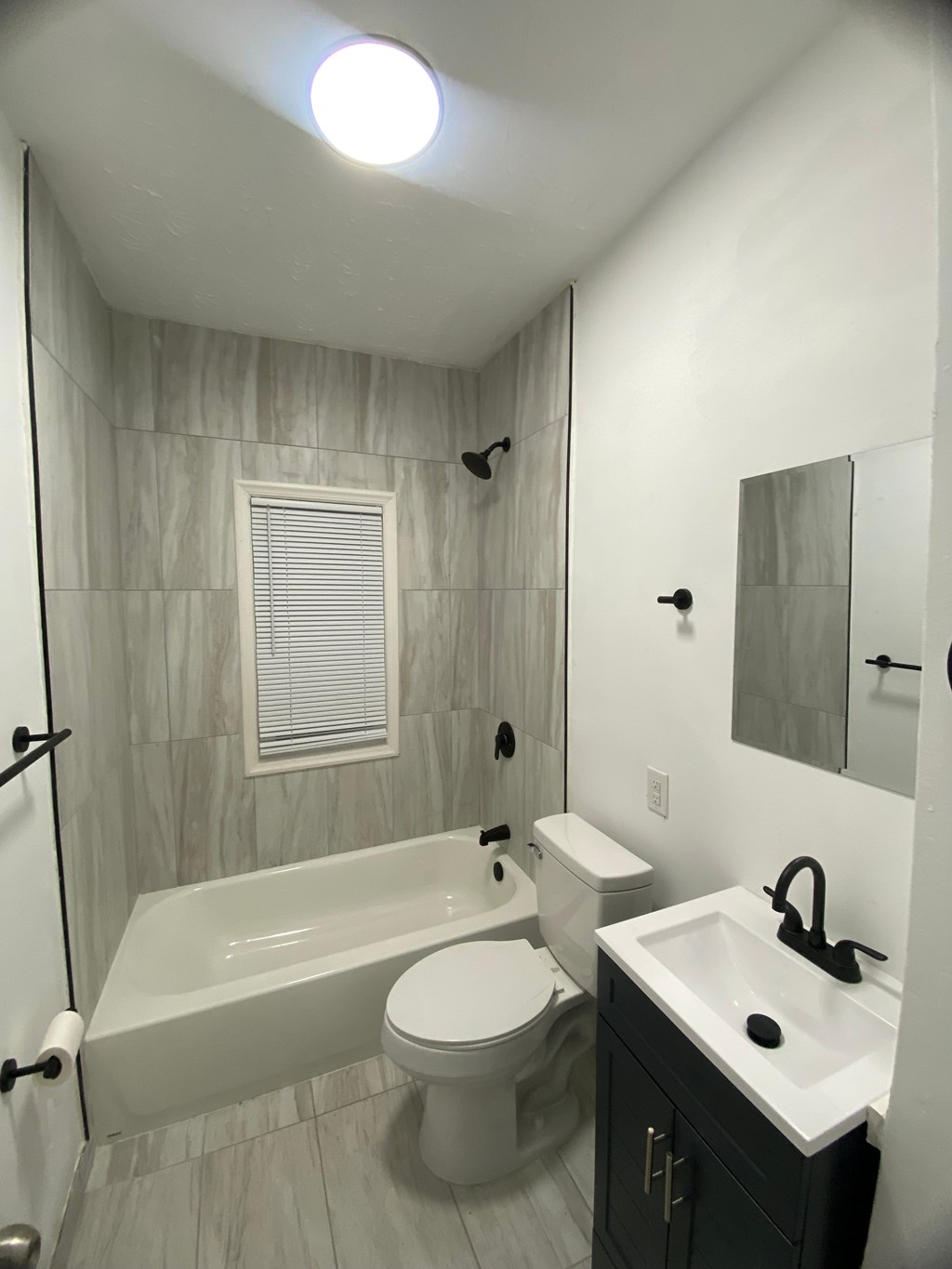 A white toilet sits next to a bathtub in a bathroom.