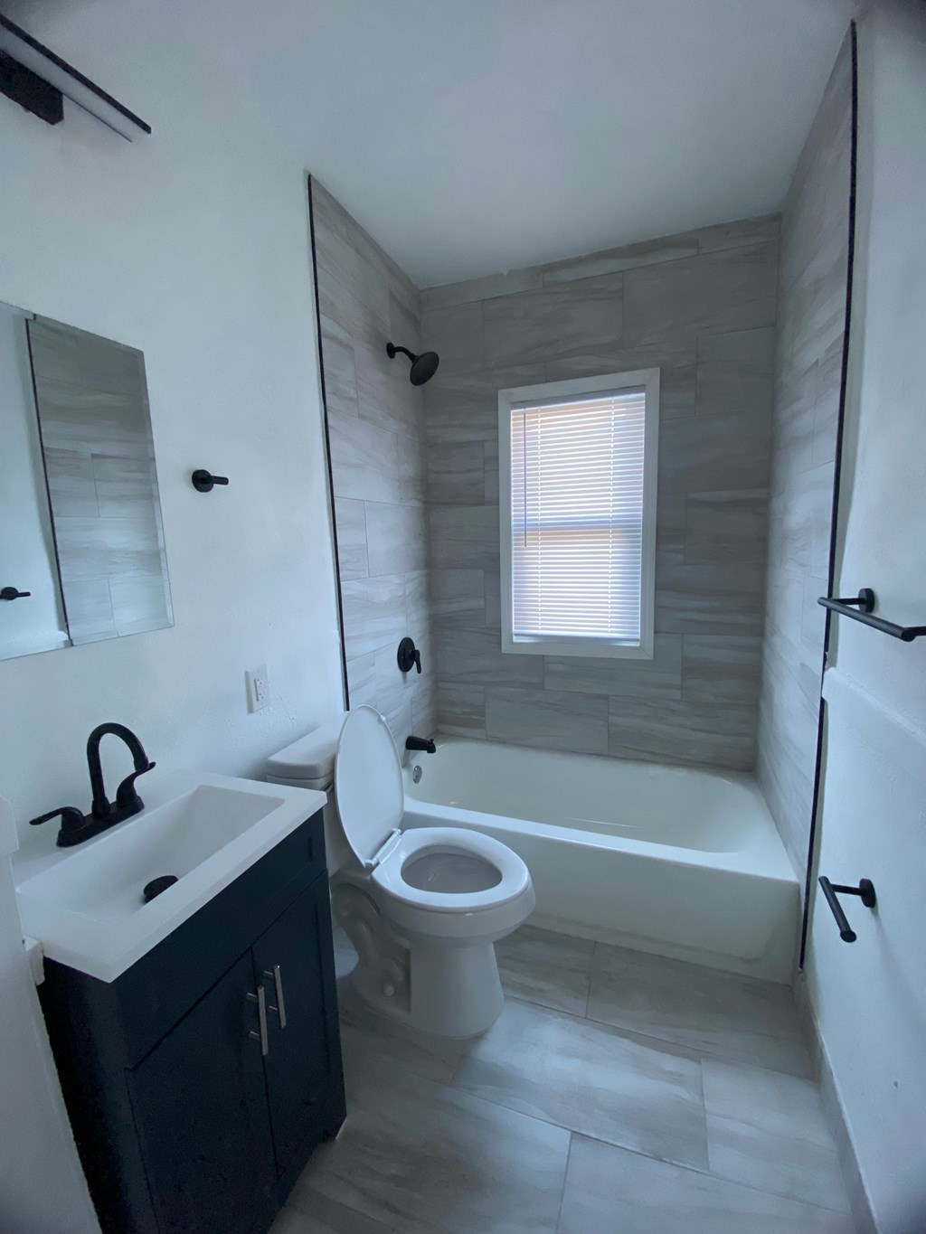 A bathroom with a toilet, sink, and tub.
