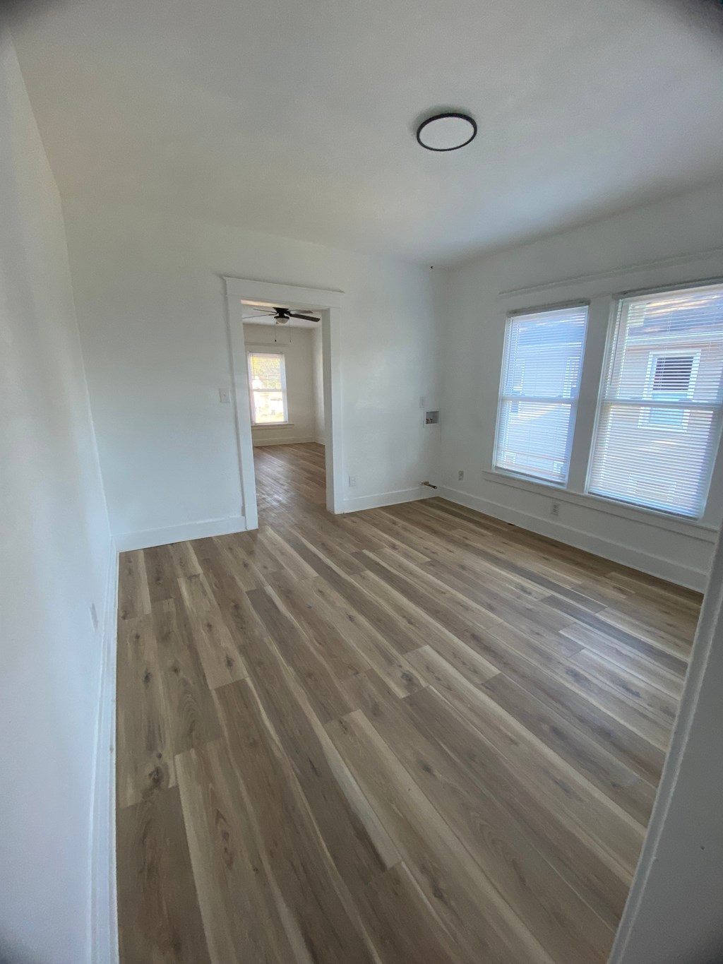 A room with wooden flooring and a window.