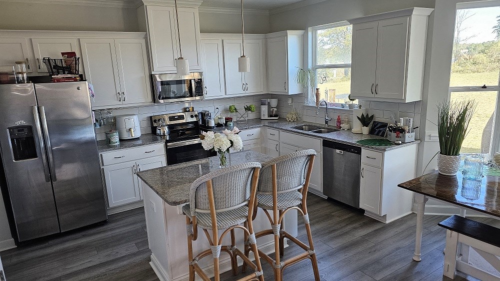 A kitchen with a table and chairs in front of it.