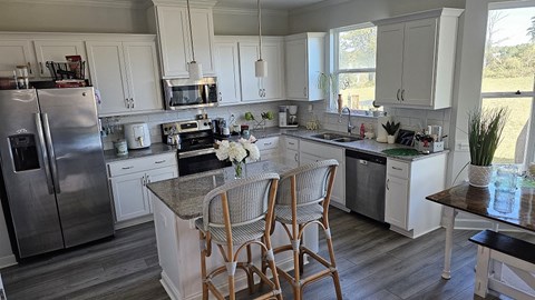 A kitchen with a table and chairs in front of it.