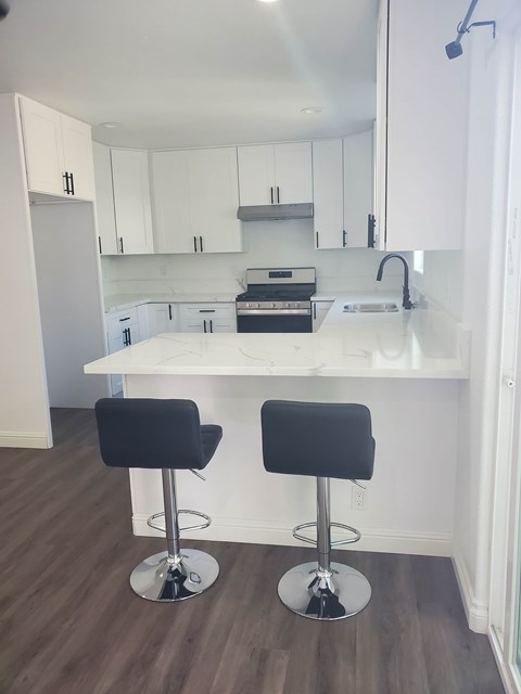Two black barstools are in front of a white kitchen island.