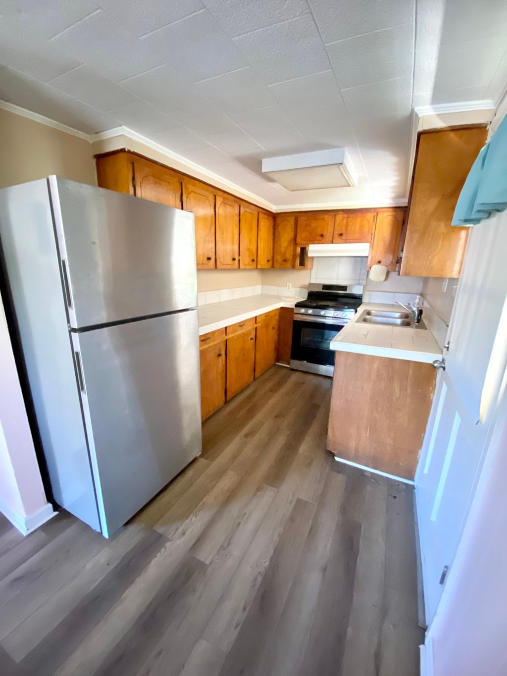 a kitchen with wooden cabinets and a refrigerator