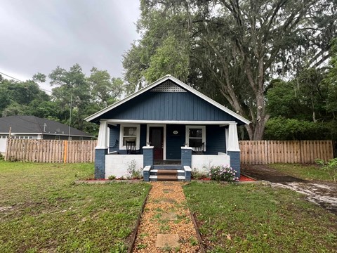 A blue house with a white door and windows.