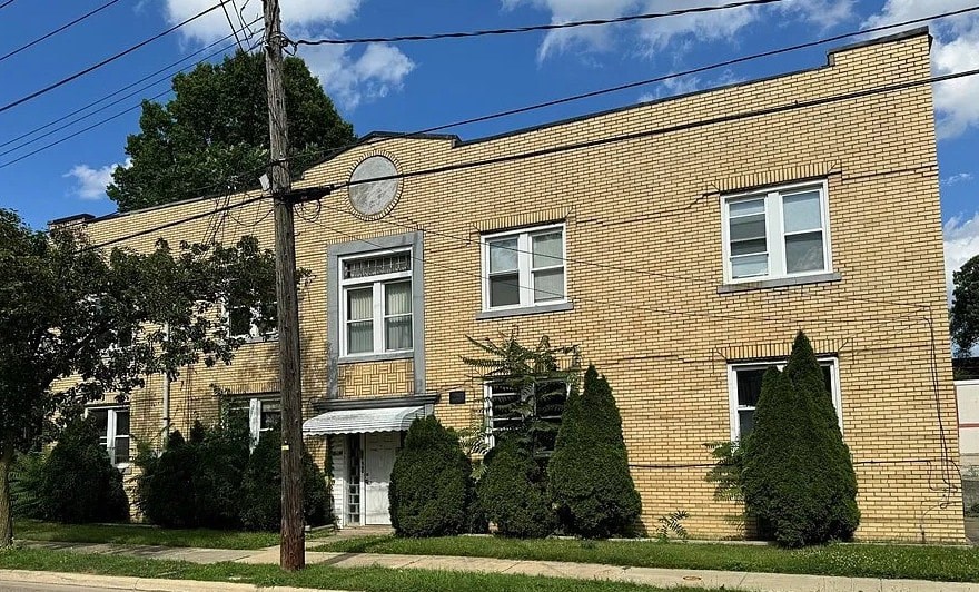 A brick building with a white door and windows.