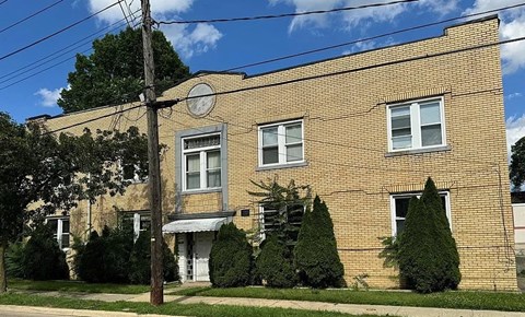 A brick building with a white door and windows.