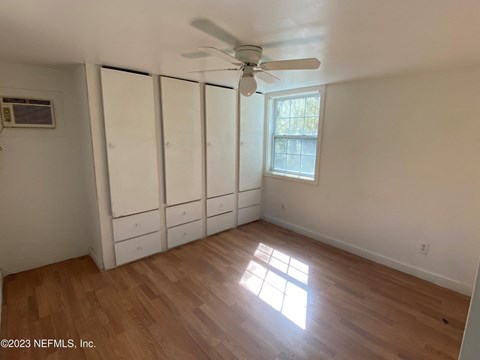 a bedroom with white closets and a ceiling fan