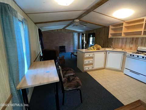 A living room with a couch, chair, and television.