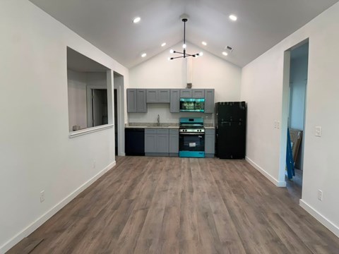 A kitchen area with a black refrigerator and a sink.
