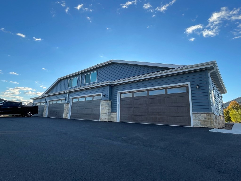 a blue house with a garage with a car parked in front of it