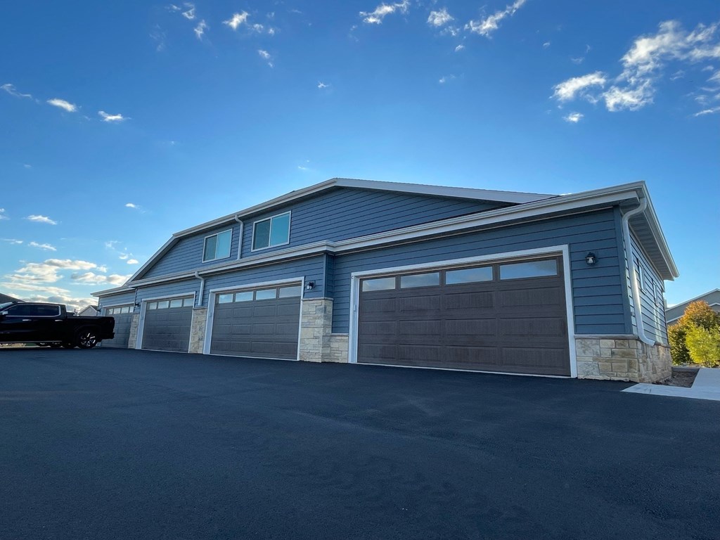 a blue house with a garage with a car parked in front of it