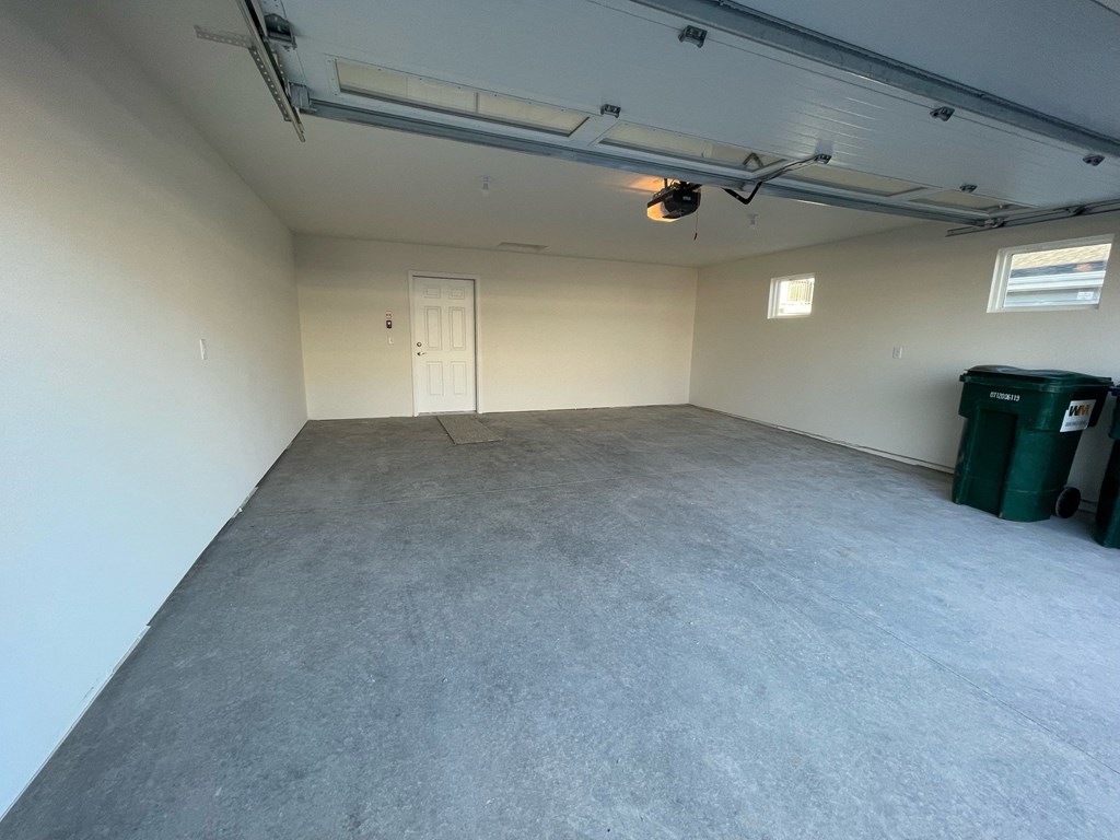 the interior of a garage with a concrete floor and white walls
