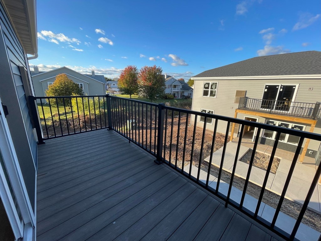 a balcony with a view of a house and a blue sky