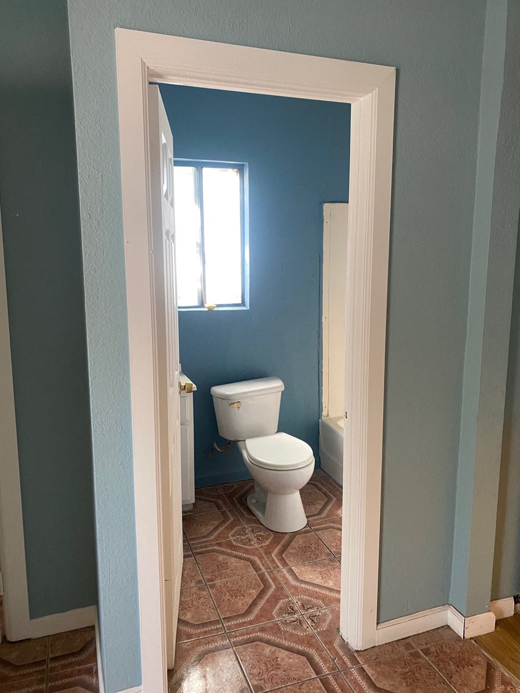 a bathroom with a toilet and a window