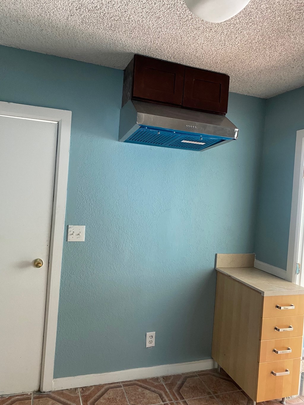 a room with blue walls and a ceiling fan and a dresser
