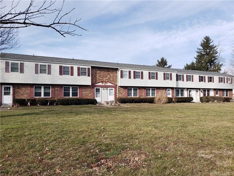 a view of an apartment building with a grassy yard