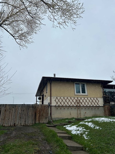 A house with a brown fence and a white window.