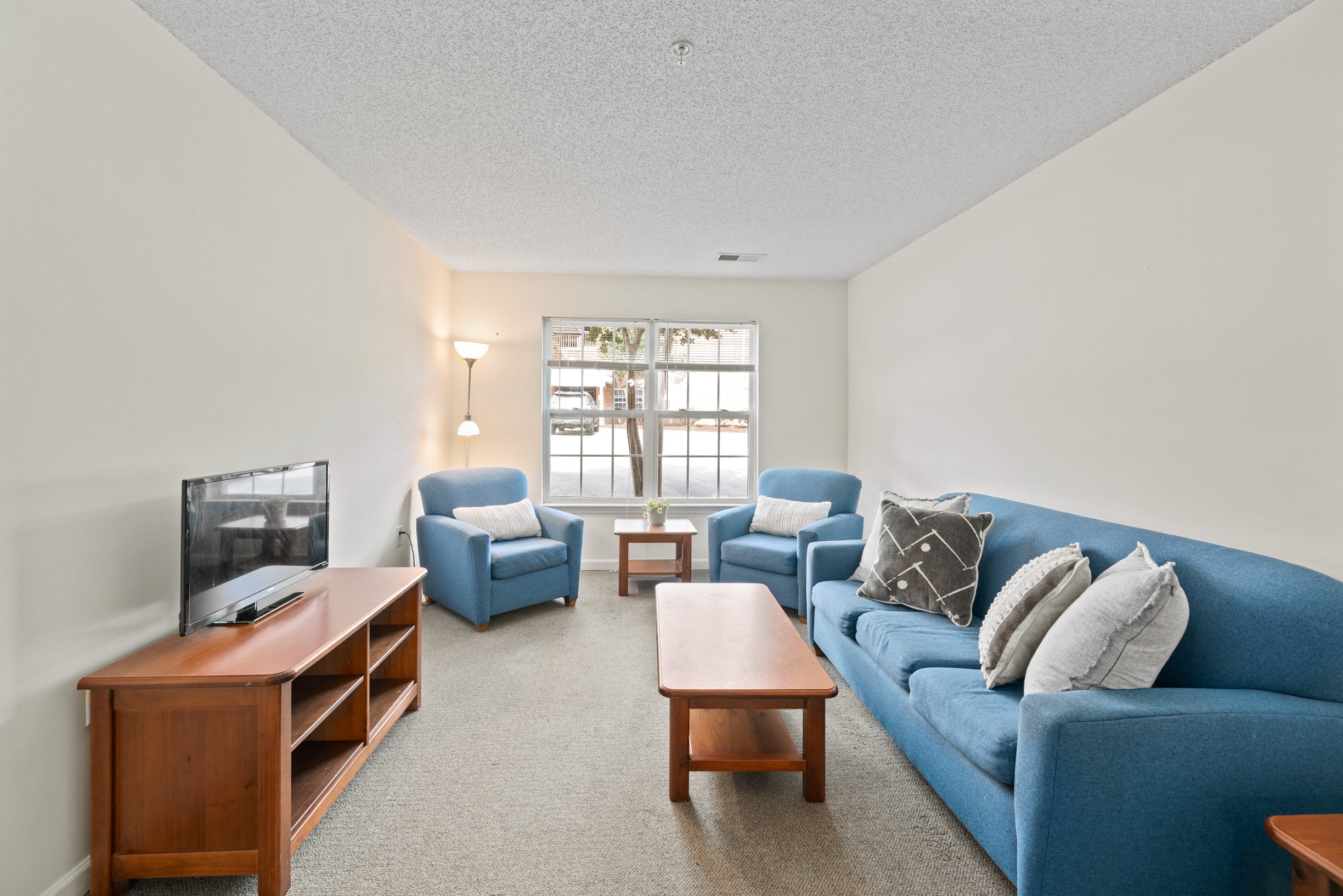 a living room with a blue couch and a tv