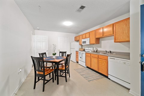 A kitchen with a table and chairs in the middle of the room.