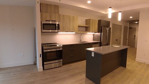 A kitchen with wooden cabinets and a stainless steel refrigerator.